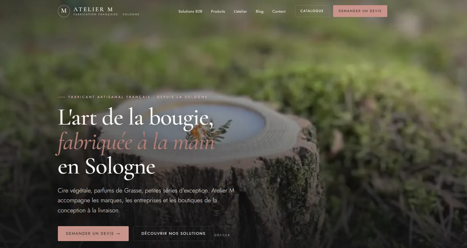 Page d’accueil du site Atelier M : « L’art de la bougie, fabriquée à la main en Sologne », avec navigation Solutions B2B, catalogue et demande de devis.